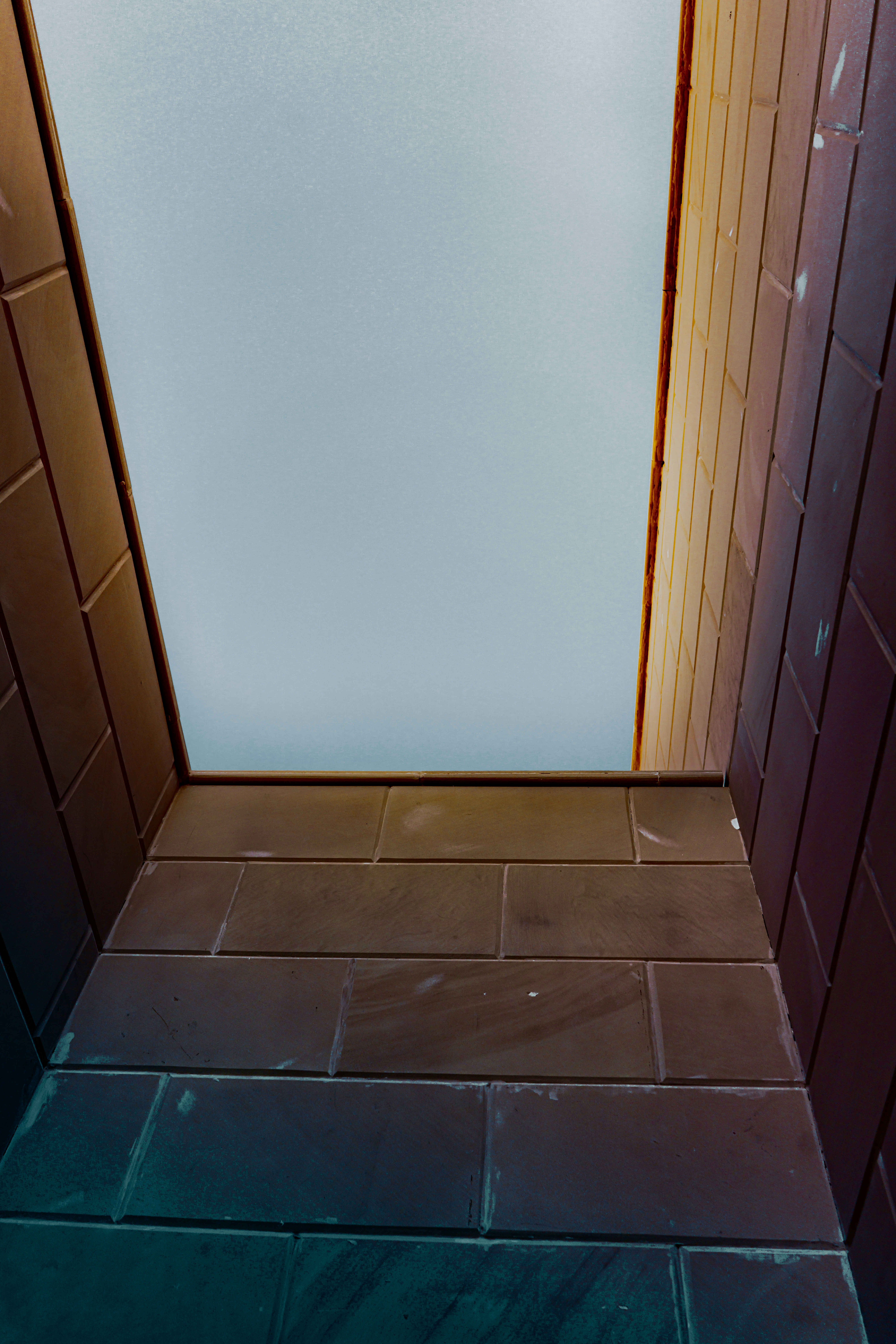 A bathroom with a toilet and a tiled floor
